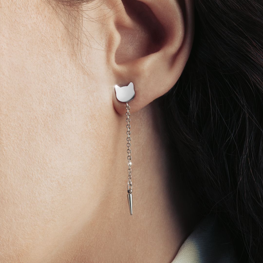 Model wearing silver cat head drop earring.