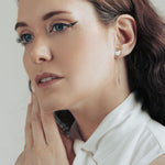 Model wearing a stainless steel cat head drop earring, full face visible.