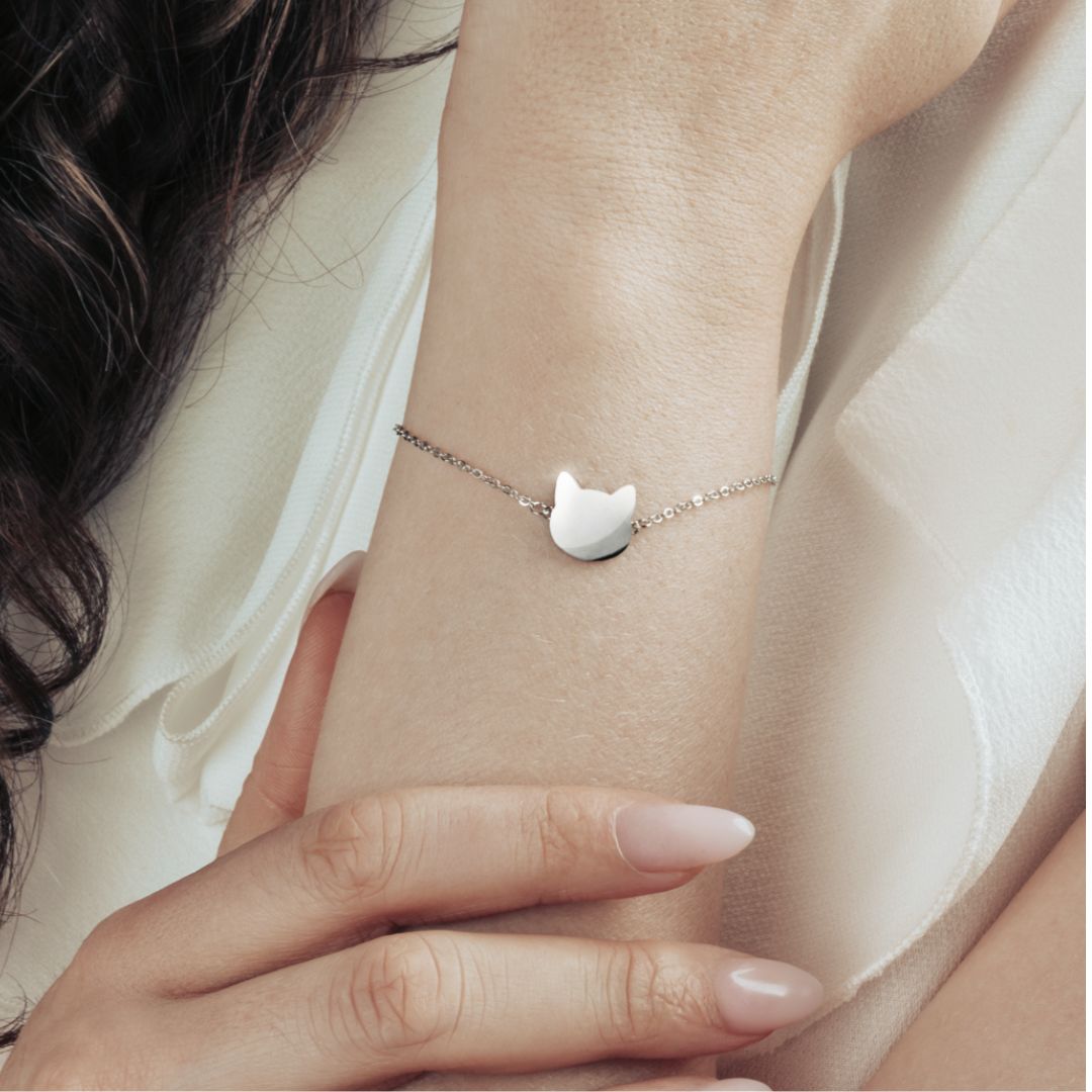 Model wearing a silver bracelet with simple and elegant cat head pendant.