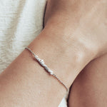 Close-up image of model wearing a silver cat mom bracelet.