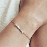 Close-up image of model wearing a silver cat mom bracelet.