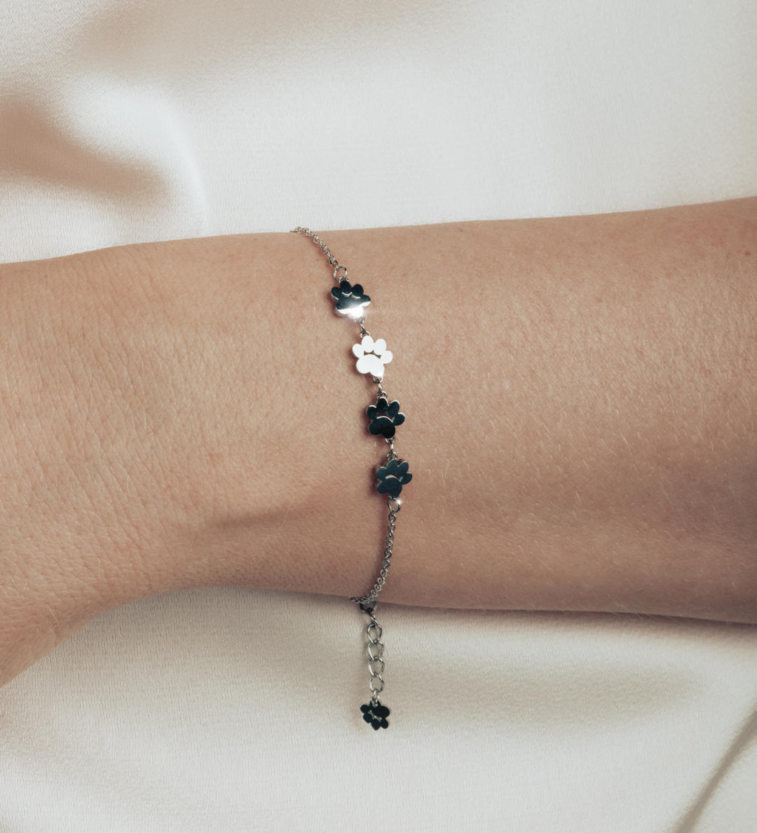A model is wearing silver bracelet featuring four cute kitty paws.