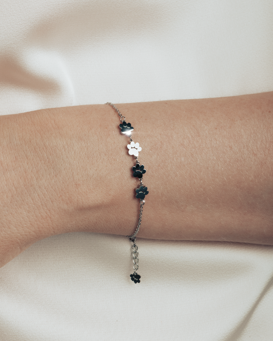 A model is wearing silver bracelet featuring four cute kitty paws.
