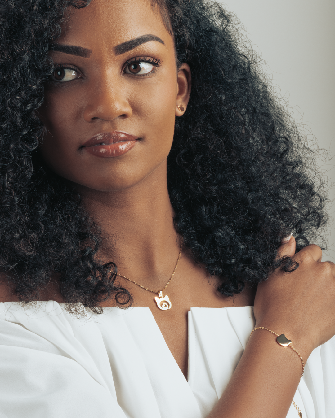 Close-up of model showcasing gold cat head necklace with heart detail, perfect for everyday wear.