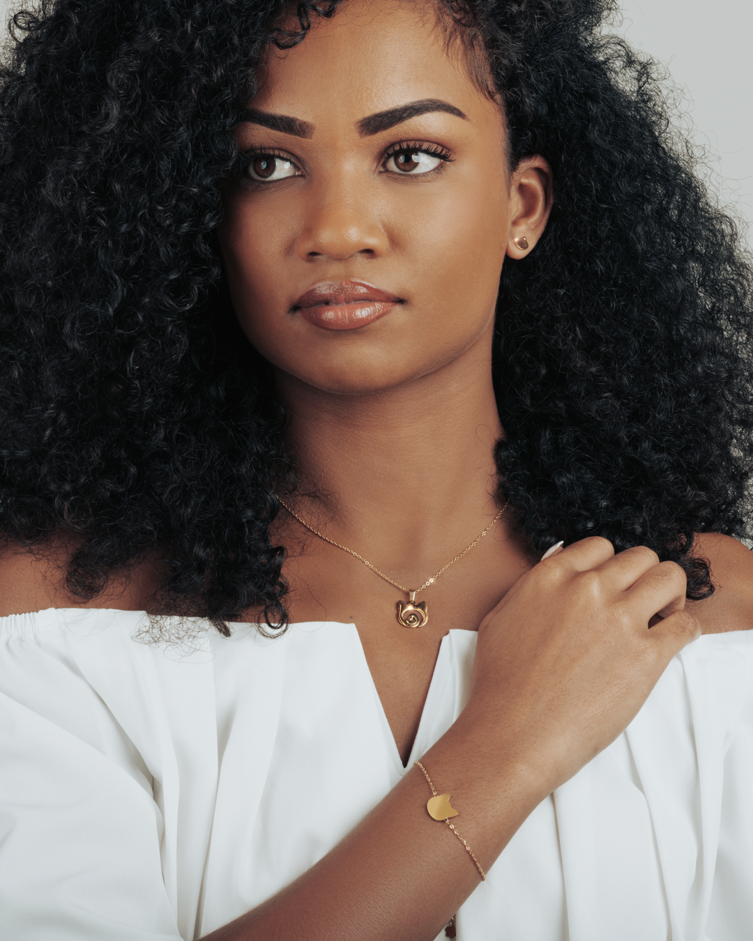 Gold cat head pendant with a heart detail, worn by model for a minimal and timeless look.