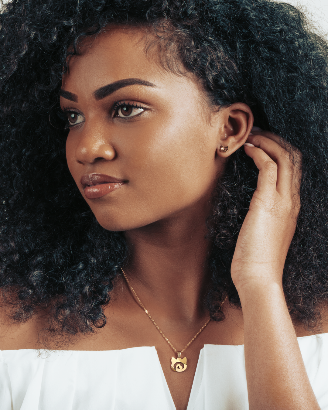 Model wearing a gold cat pendant, a subtle and elegant way to show feline love.