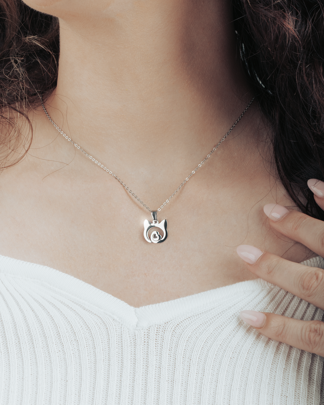Close-up of silver cat necklace with heart detail on model’s neck, perfect for everyday wear.
