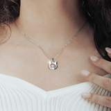 Close-up of silver cat necklace with heart detail on model’s neck, perfect for everyday wear.
