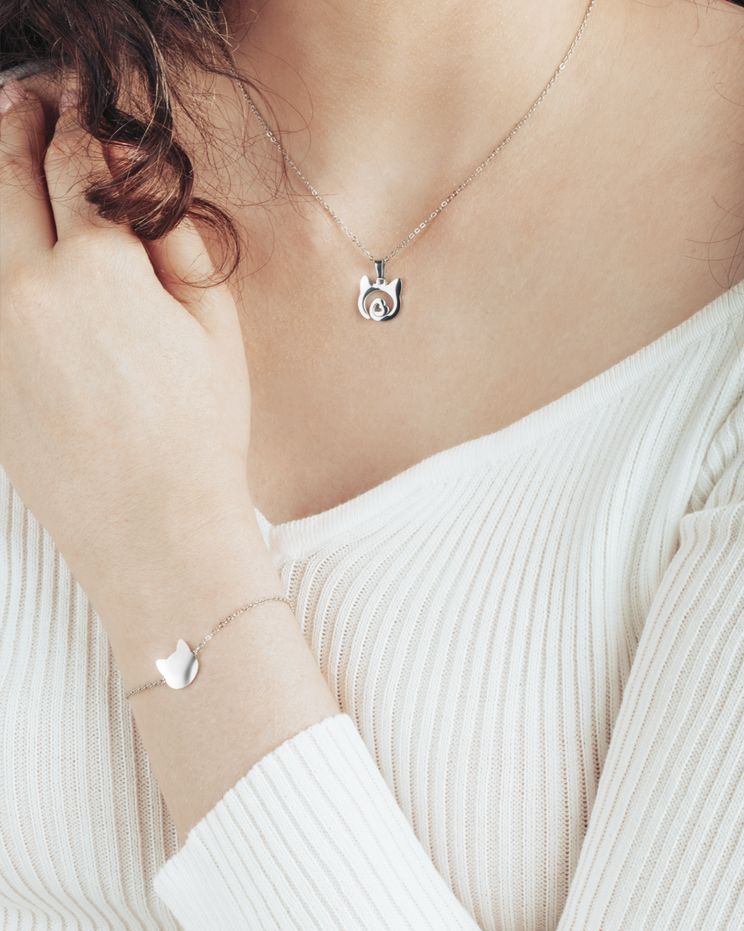 Silver cat silhouette necklace with heart detail, and a matching bracelet for a chic and timeless style.