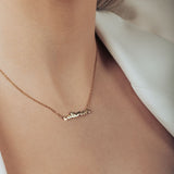 Model wearing gold necklace with handwritten-style cat mom letters and heart in the middle.