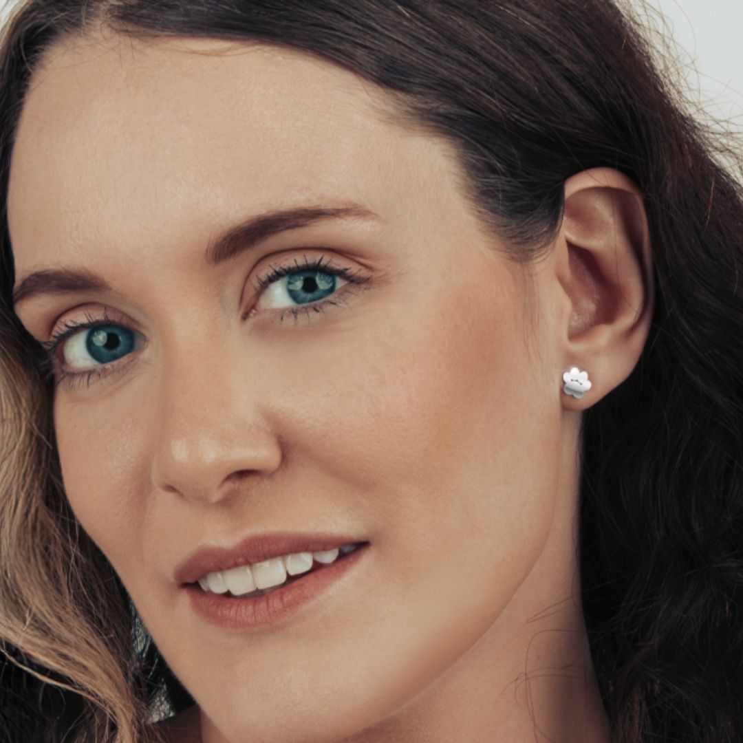 Model wearing a silver cat paw shaped stud earrings.