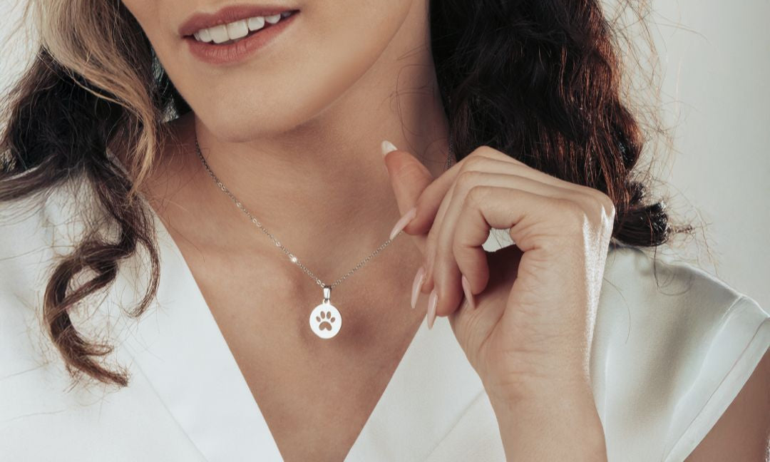 Model wearing the silver paw print necklace and matching bracelet for a stylish, coordinated look.