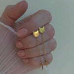 Video showing a female hand holding a gold cat head drop earrings.