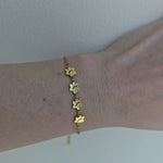 Gold Pretty4Paws bracelet shining on model's wrist, showcasing its elegant and minimalist design.