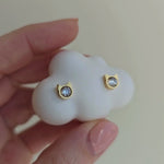 Video showing gold stud earrings in the cat head shape with zirconia in the middle.