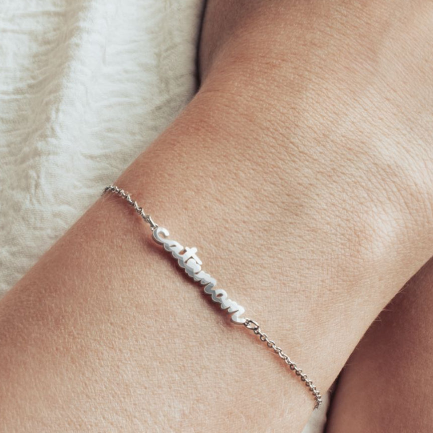 Close-up image of model wearing a stainless steel cat mom bracelet. 