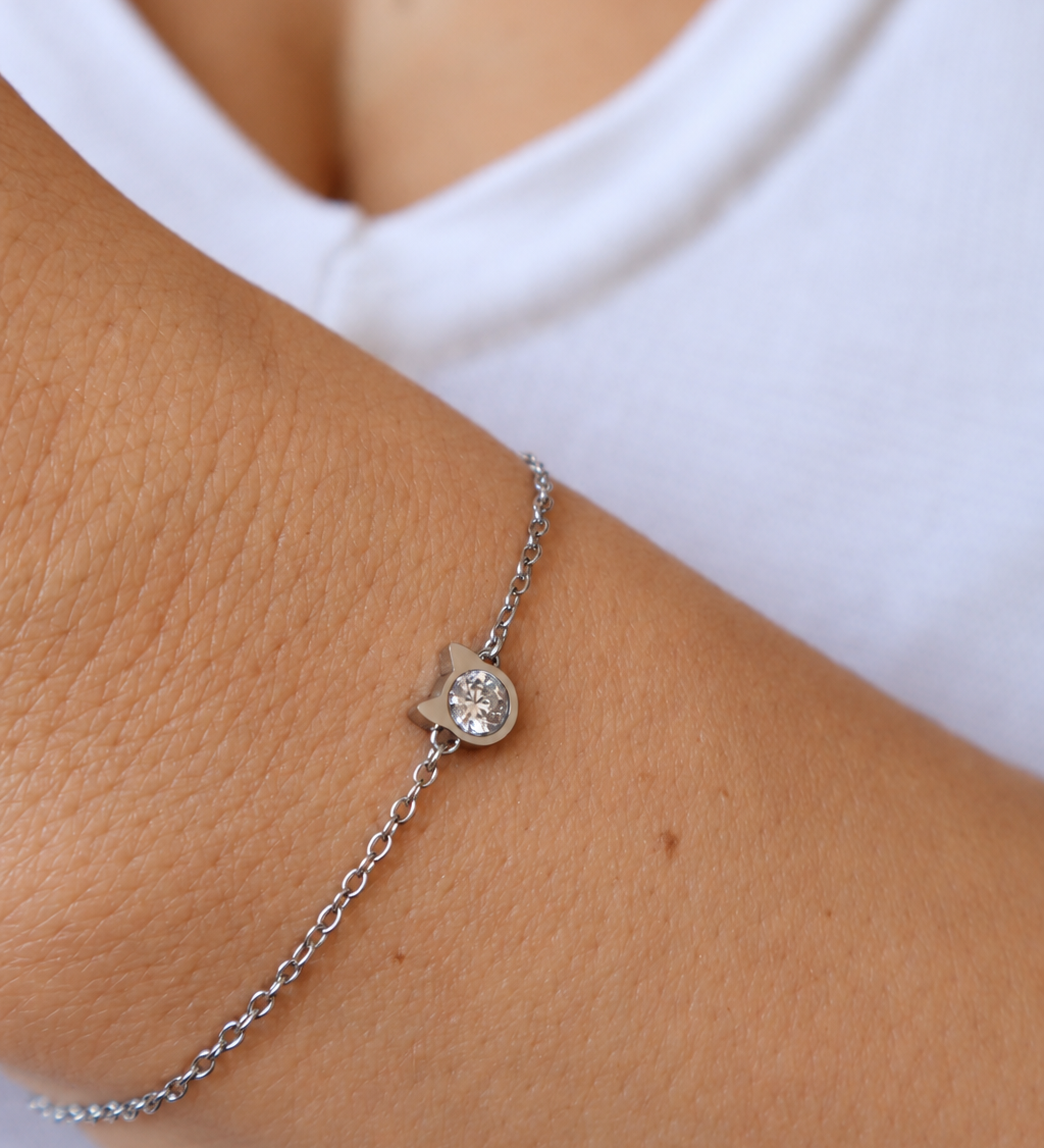 Kitty’s Sparkle cat bracelet worn on a wrist against a white top, showing the silver-tone cat-head setting and sparkling centre.