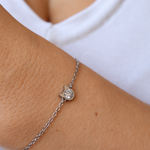 Kitty’s Sparkle cat bracelet worn on a wrist against a white top, showing the silver-tone cat-head setting and sparkling centre.