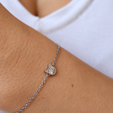 Kitty’s Sparkle cat bracelet worn on a wrist against a white top, showing the silver-tone cat-head setting and sparkling centre.