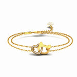 A gold double-strand chain bracelet featuring a central interlocking heart and cat head design, having heart outlined with small clear crystals, with an adjustable lobster clasp and a small paw shaped charm, shown on a white background.