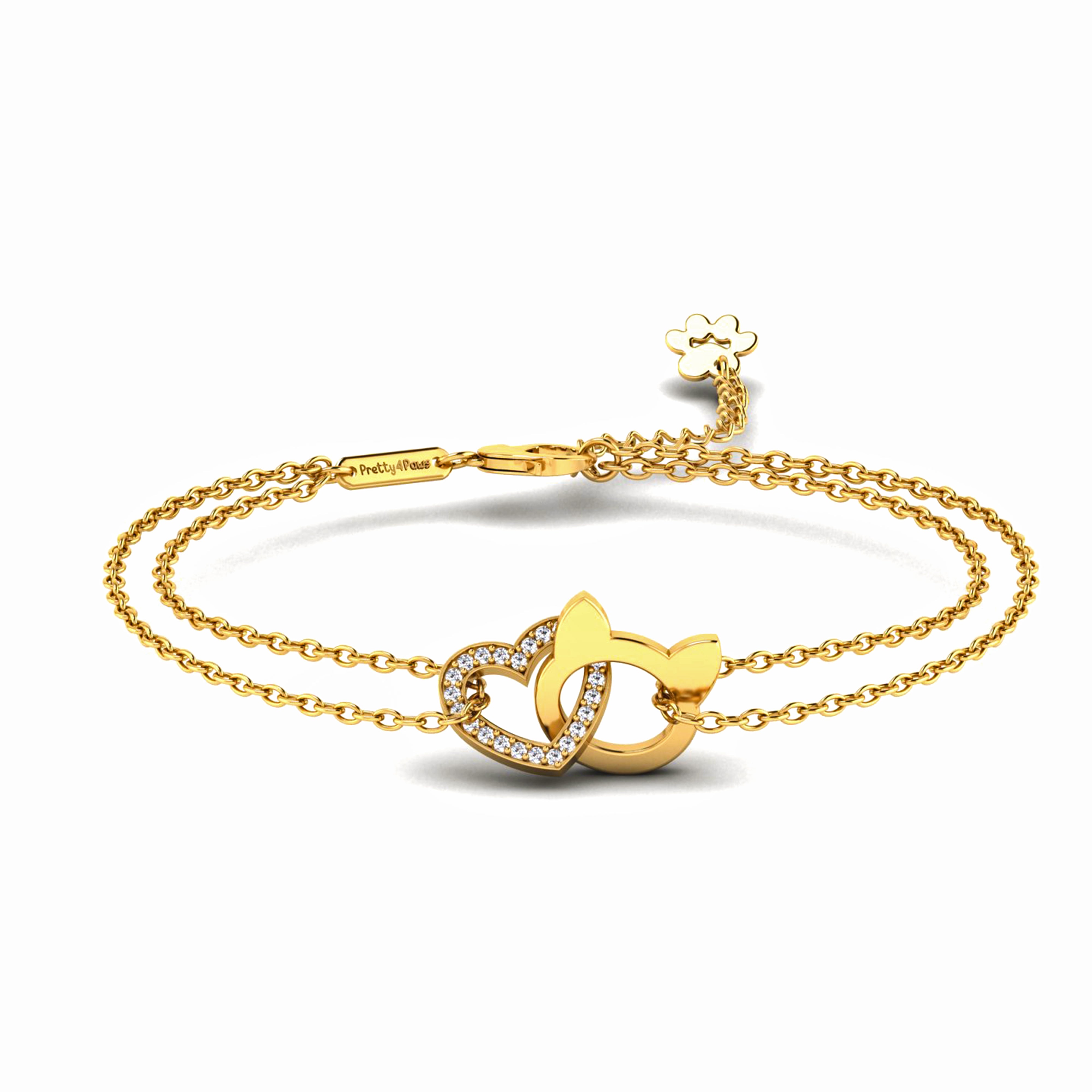 A gold double-strand chain bracelet featuring a central interlocking heart and cat head design, having heart outlined with small clear crystals, with an adjustable lobster clasp and a small paw shaped charm, shown on a white background.