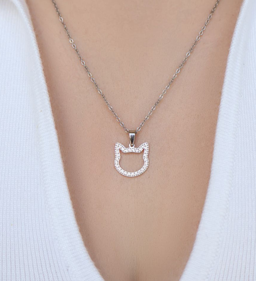A model wearing elegant necklace with silver cat pendant on her neck. 