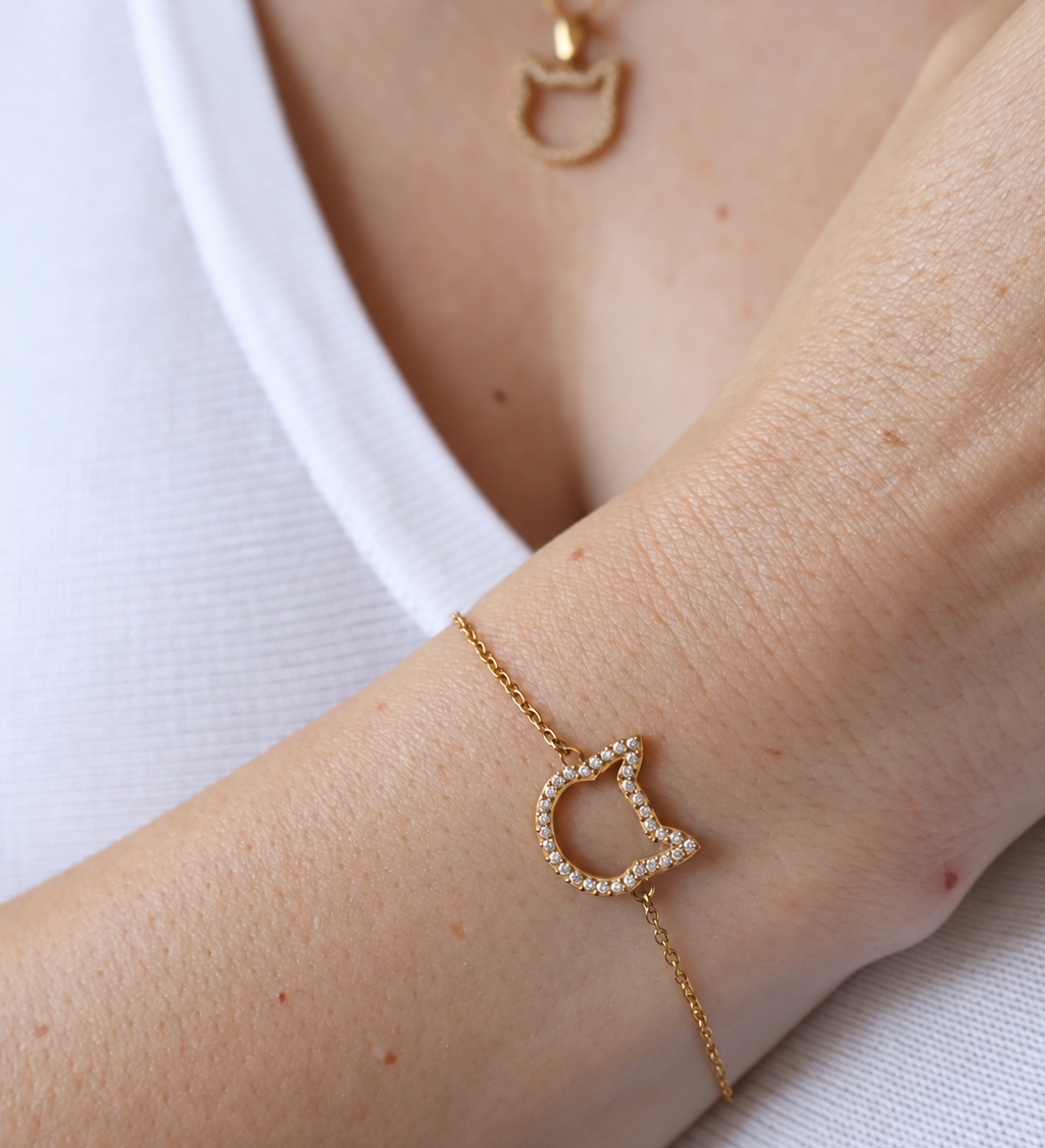 Magical Meow cat bracelet worn on a wrist with a matching cat-head necklace and white top.
