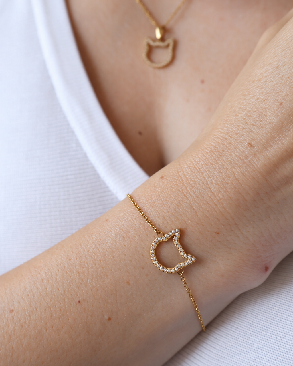 Magical Meow cat bracelet worn on a wrist with a matching cat-head necklace and white top.