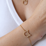 Magical Meow cat bracelet worn on a wrist with a matching cat-head necklace and white top.