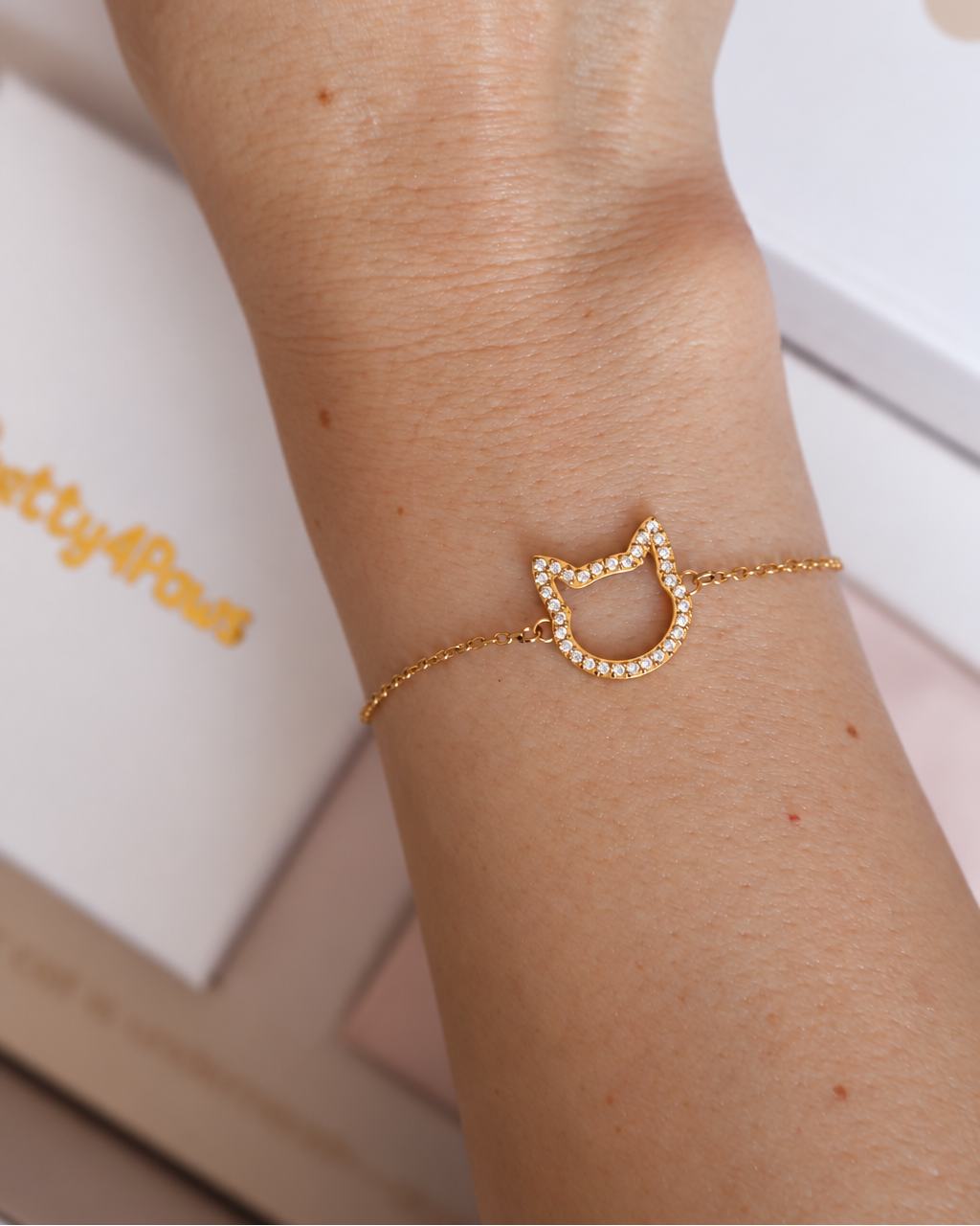 Close-up of the Magical Meow bracelet on a wrist, showing its sparkling open cat-head outline and fine chain.