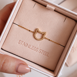 Magical Meow cat bracelet displayed in an ivory jewellery box with a blush insert, held by a hand with nude nails.